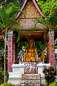 Luang Prabang, Laos - Wat Sop, pavilion with a seated Buddha statue. 